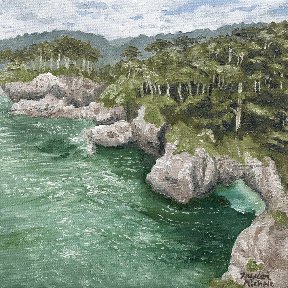 Scenic view of a coastal landscape with rocky cliffs and greenery.