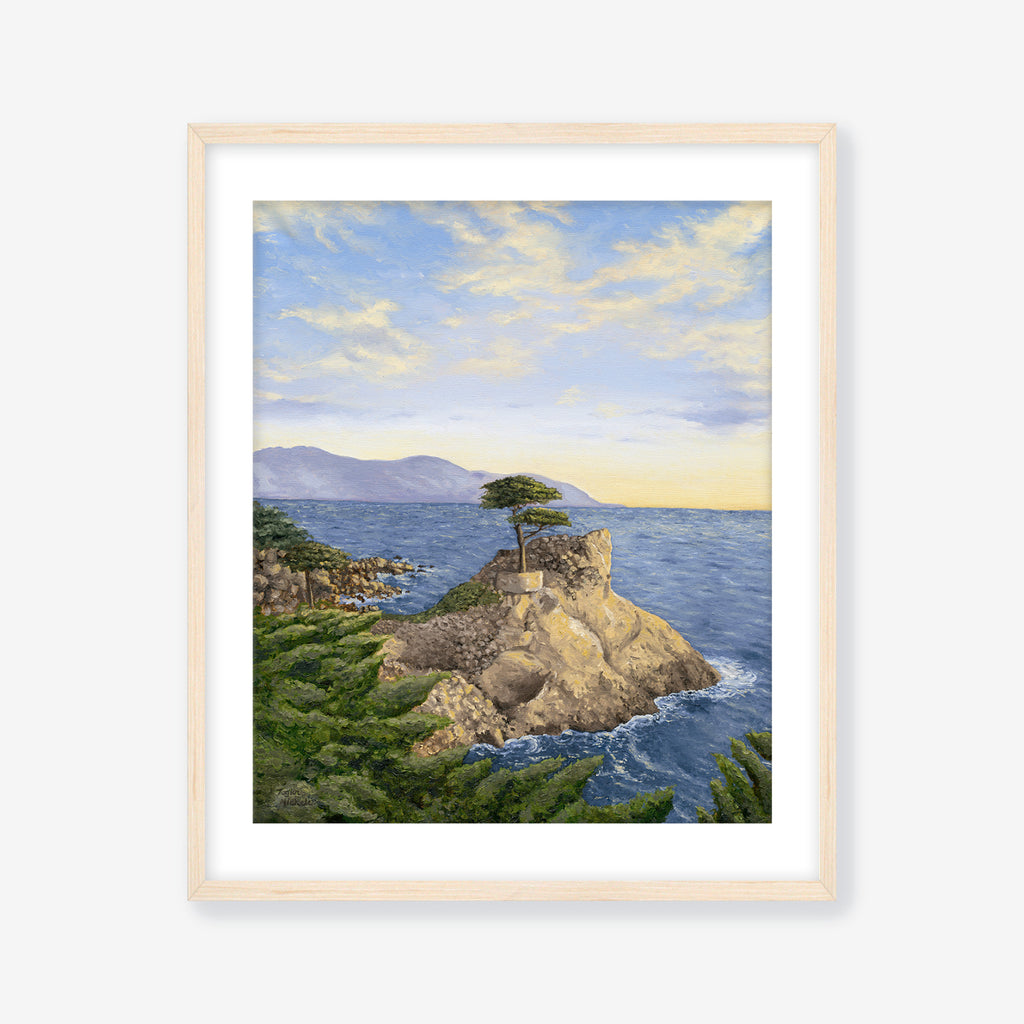 Framed artwork of a coastal landscape with a tree on a rock, blue sky, and ocean. Maple frame