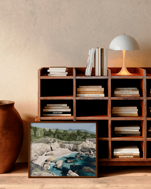 Wooden bookshelf with books and a framed picture of a natural landscape.