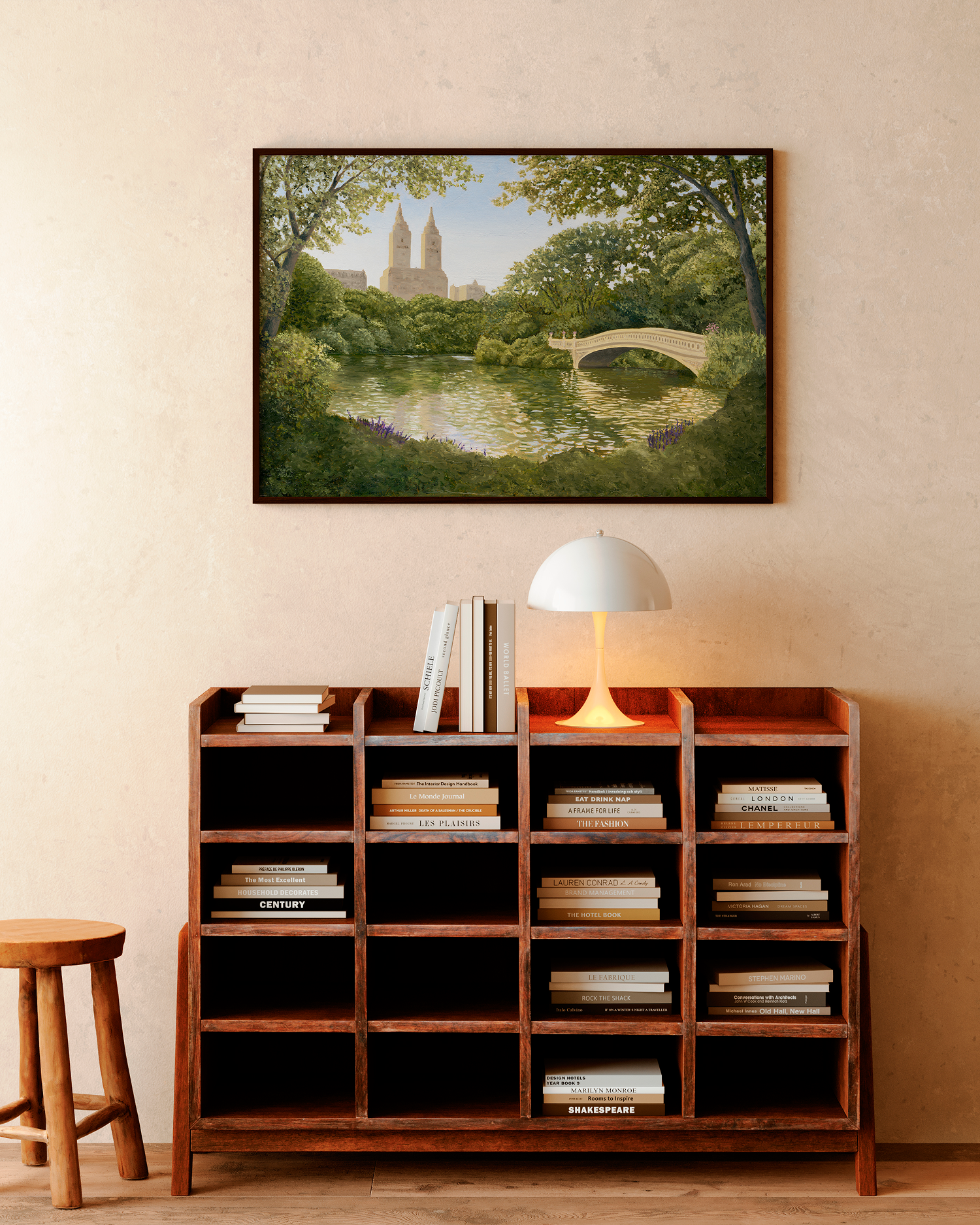 Framed artwork of a park scene above a wooden bookshelf with books.
