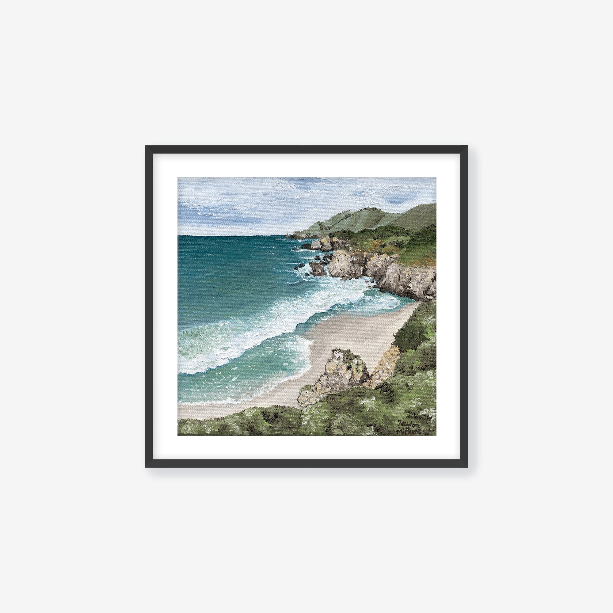 Framed artwork of a coastal landscape with ocean and beach. Black frame