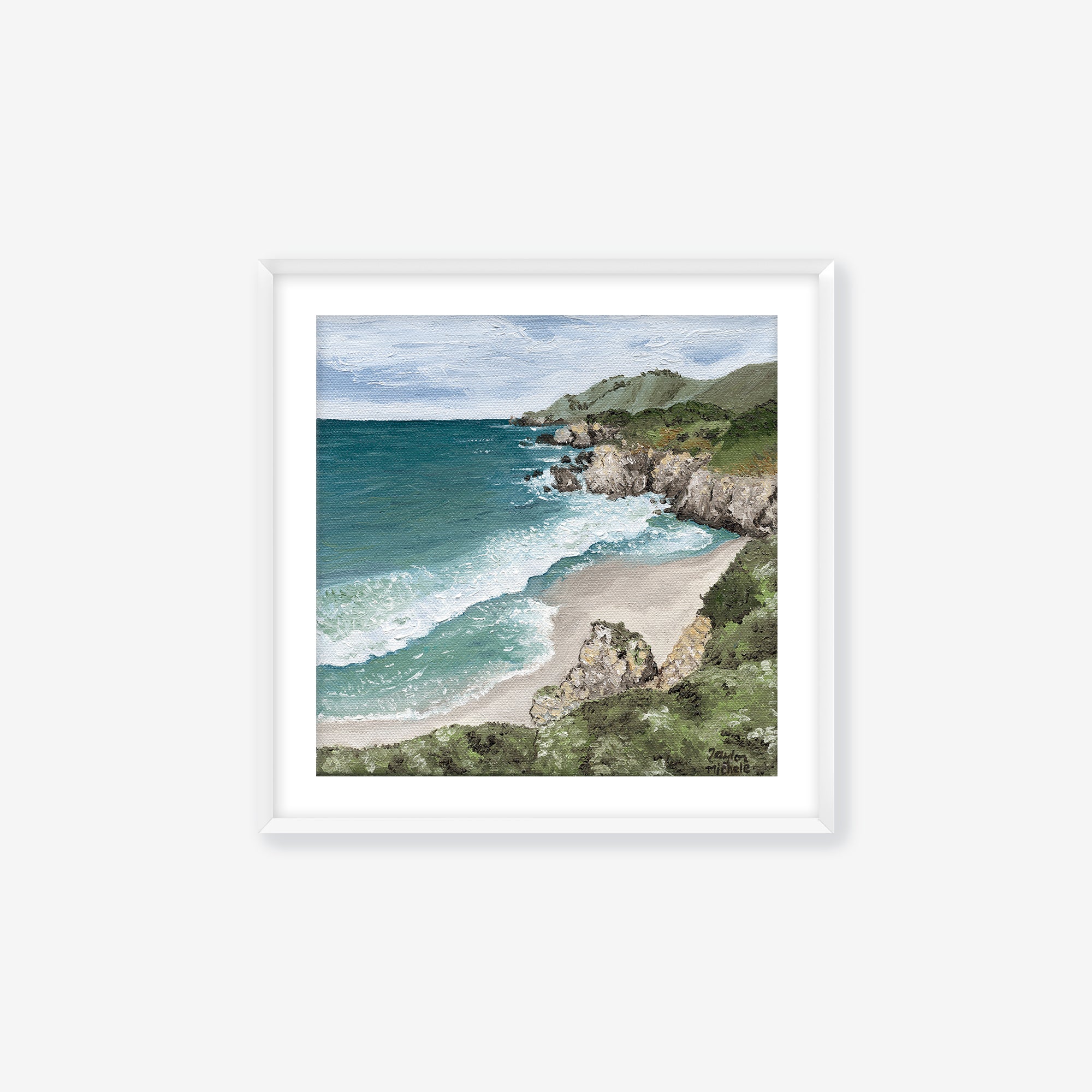 Framed artwork of a coastal scene with ocean and beach. White frame