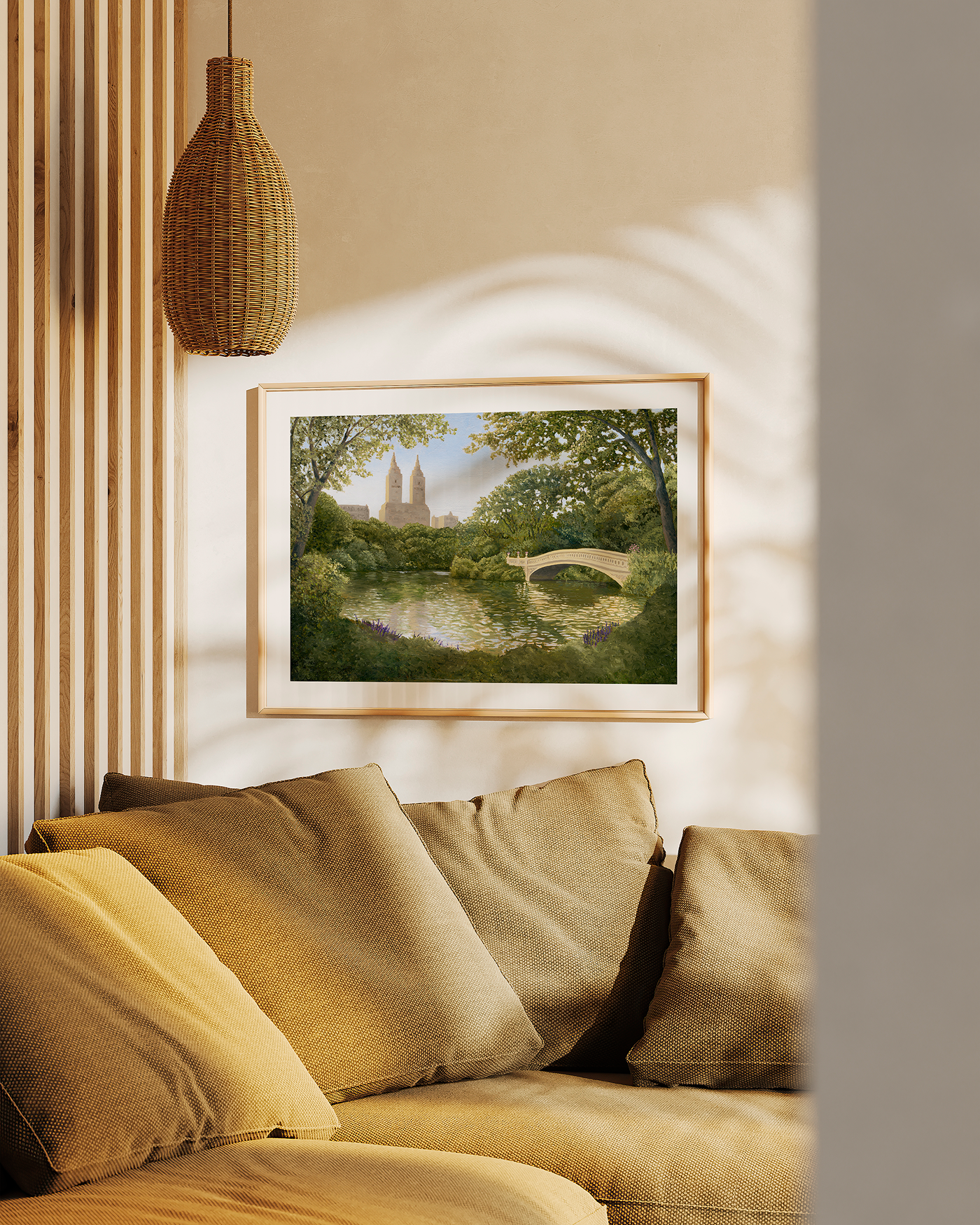 Framed artwork of a landscape with a bridge on a wall above a beige sofa.