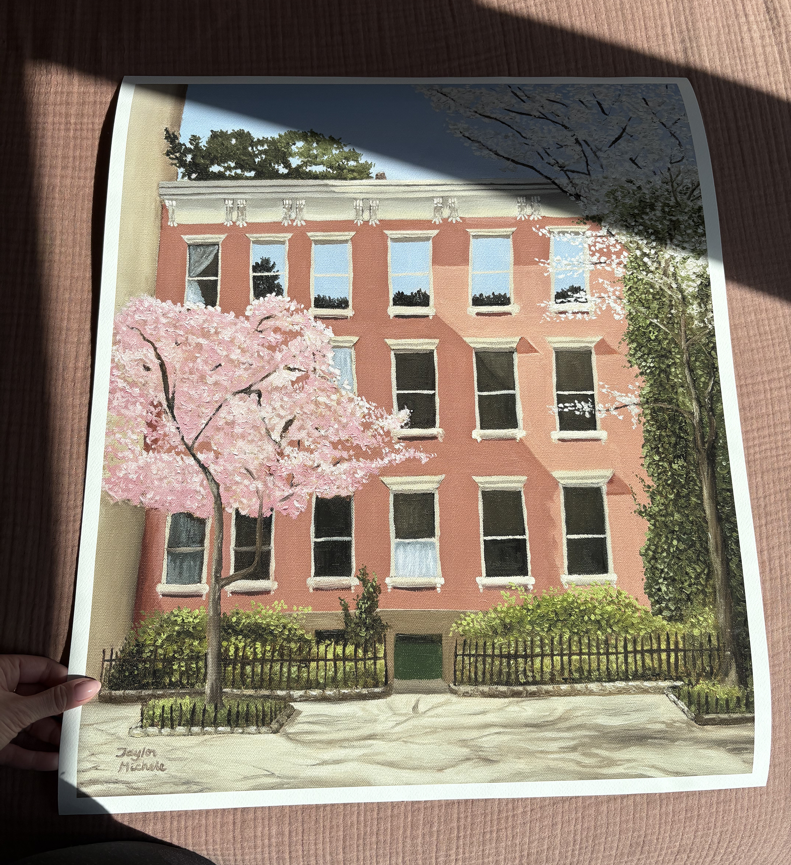 Artistic depiction of a pink building with cherry blossom trees in front